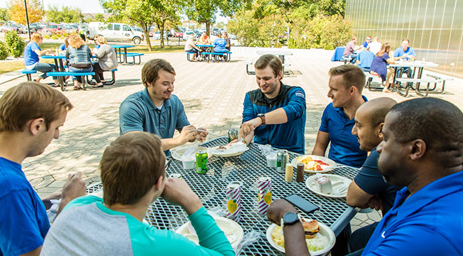Group of young professionals enjoying lunch together outside.