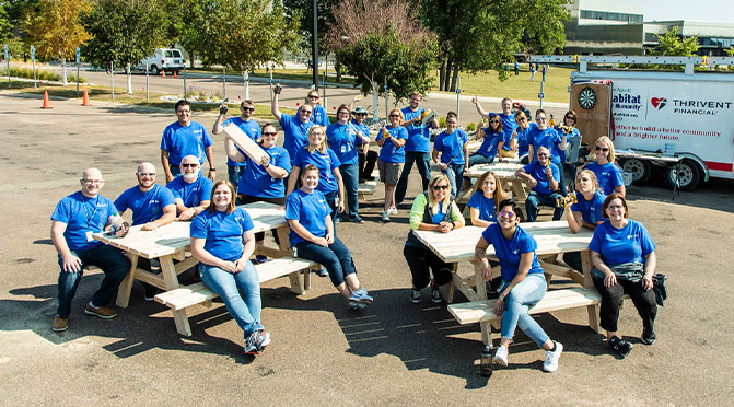 Large group of employees smiling at company work event.