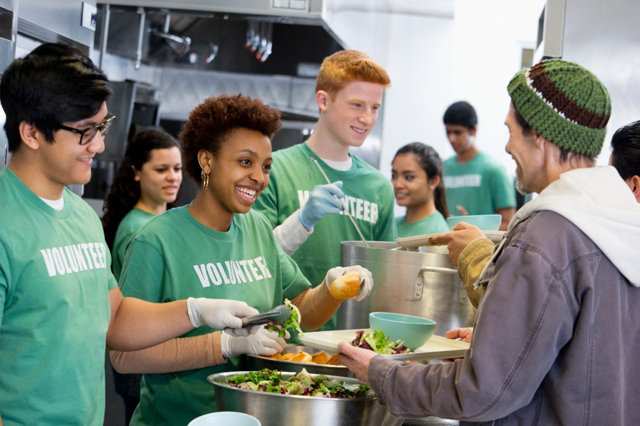 Volunteers serving a meal at a homeless shelter