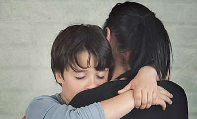 Sad child hugging his mother