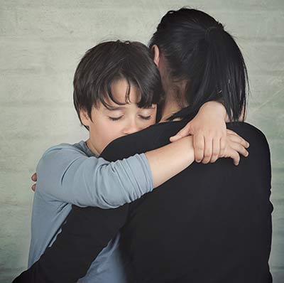 Sad child hugging his mother