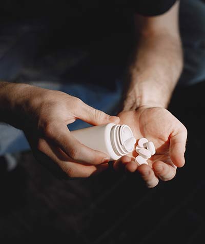 Man with pills sitting on the floor