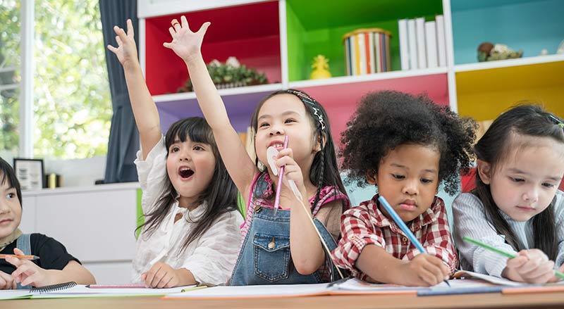 Group of little preschool kids drawing paper with colored pencils