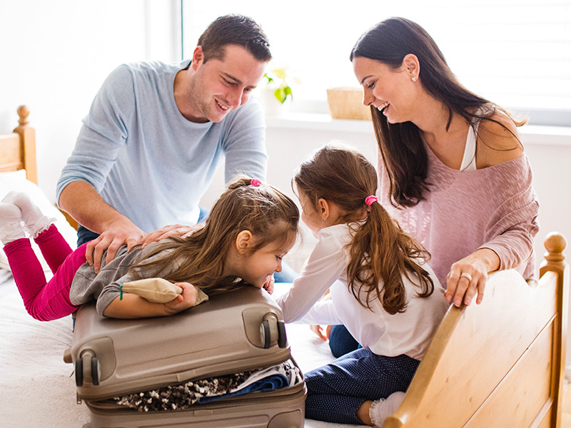 Family packing a suitcase together before a trip