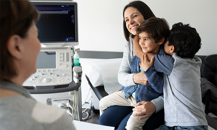 Mom with two sons in doctors office