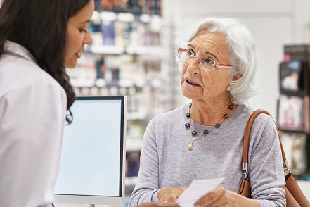 A Medicare aged woman at a pharmacy asking about a prescription