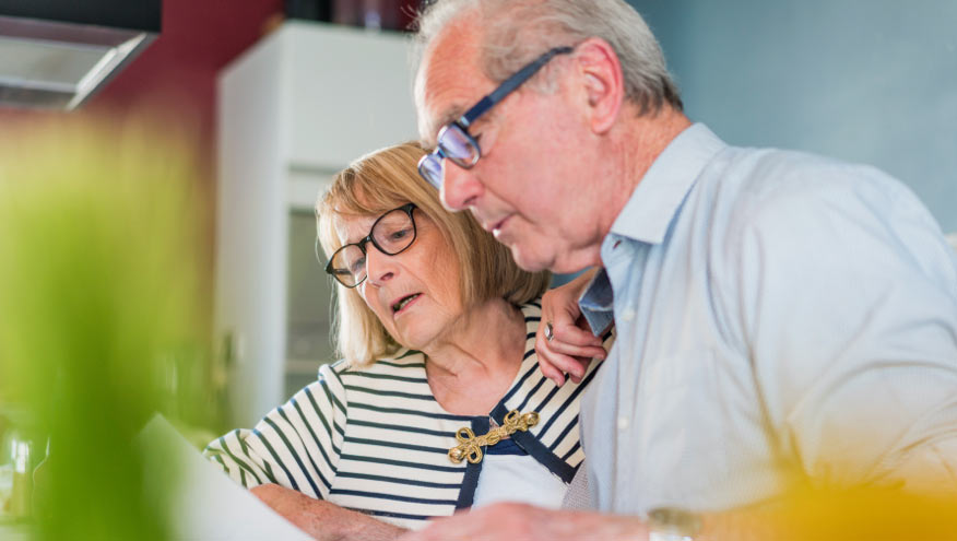 Medicare aged couple looking at papers