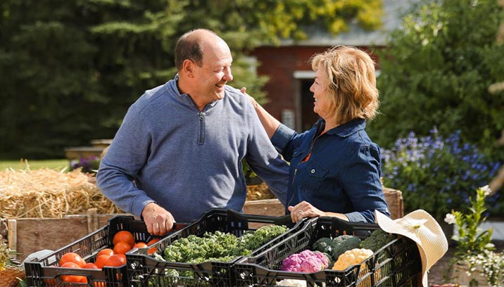 Medicare aged couple sorting vegetables at a farm