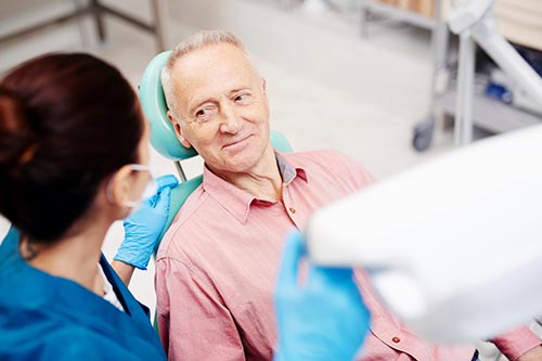 Senior man listening to dentist at checkup