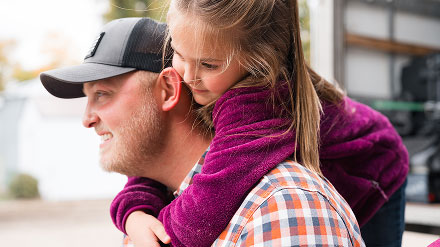 Young man with little girl on shoulders
