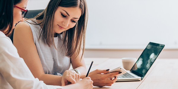 two women filling out forms