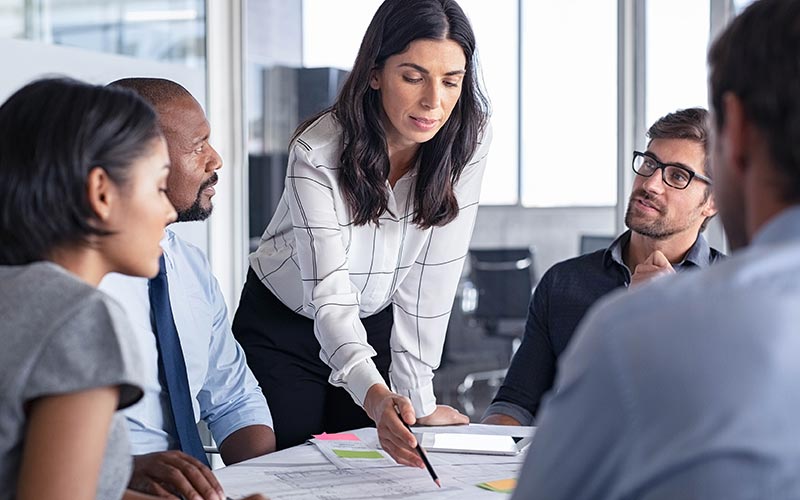 Professionals in meeting  room looking over reports