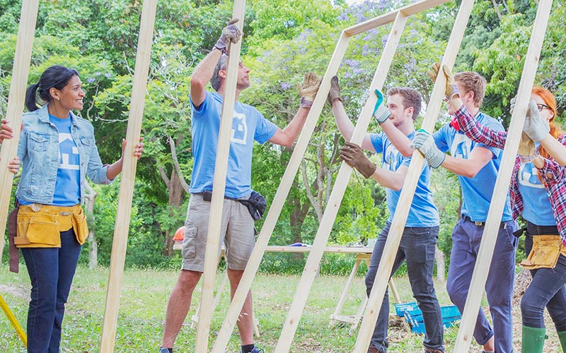 Volunteers framing a house together