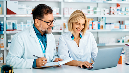 Two pharmacists working on a laptop computer