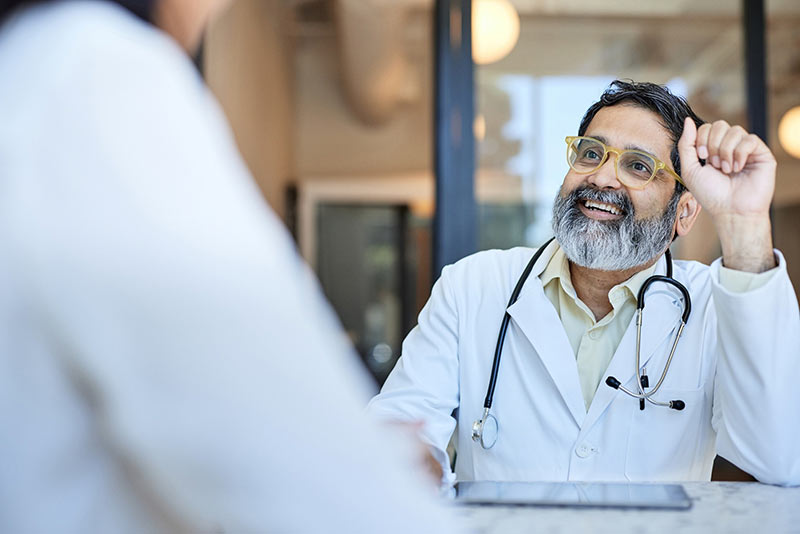 Smiling male doctor sitting at a table