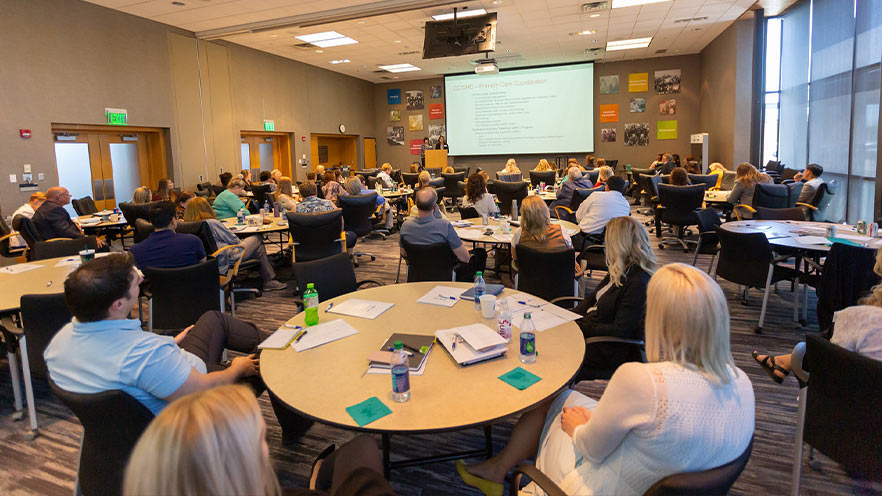 Group of employees listening to presentation at work event.