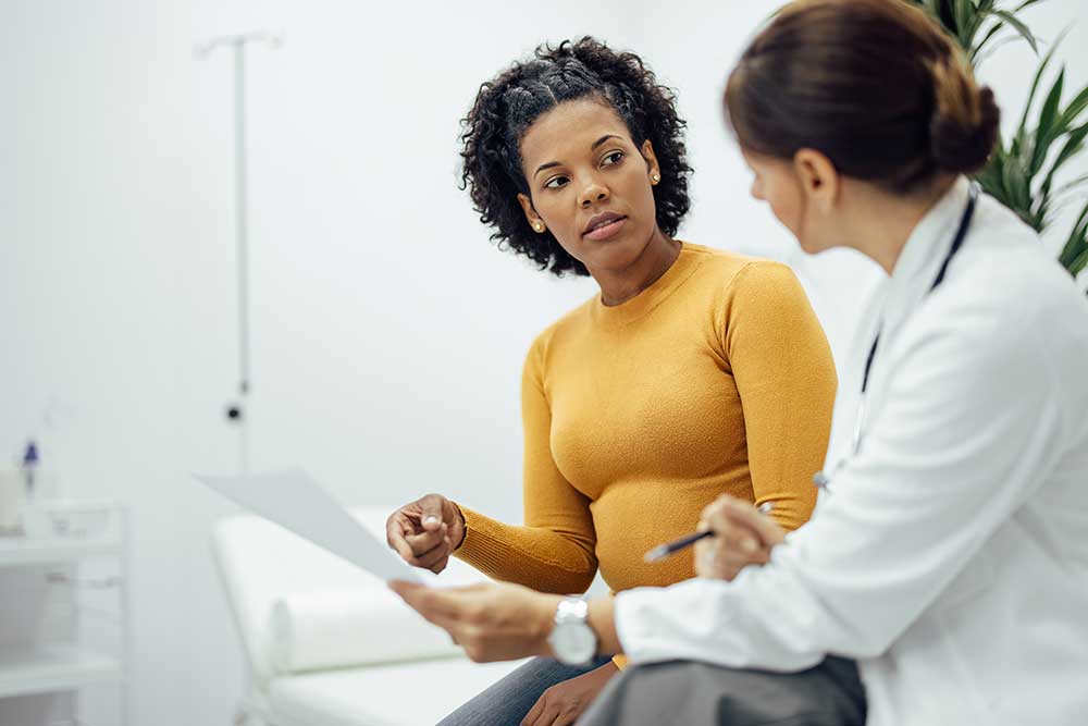 Woman and doctor discussing about medical treatment.