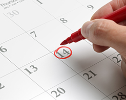 A calendar with a date being circled by a hand with a red marker