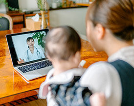 Mother and child watching video about medicine or having online consultation with doctor