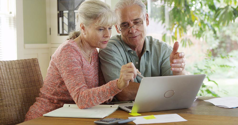 Senior couple using laptop computer to pay bills