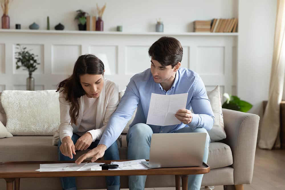 Concentrated attentive millennial spouses discussing possibility of taking bank credit