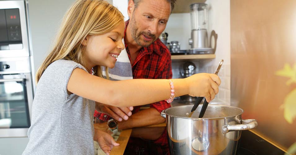 Grandfather and granddaughter cooking in the kitchen