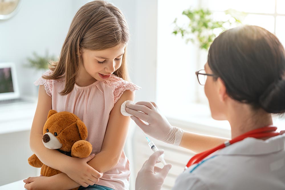 young girl getting vaccinated by a doctor