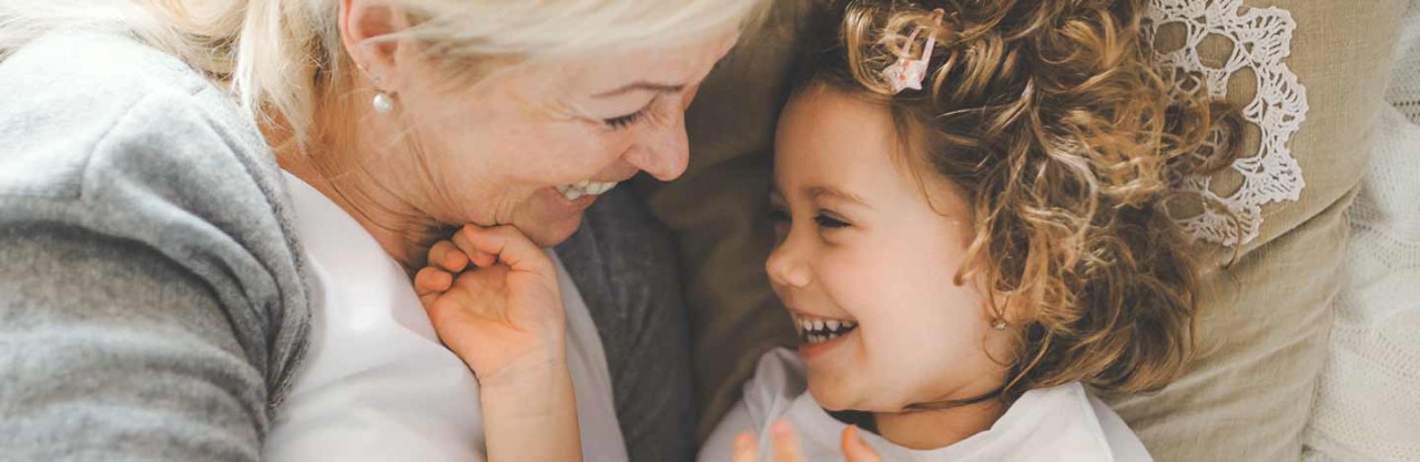 Grandmother and granddaughter giggling together