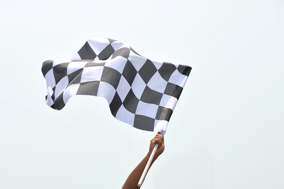 Person waving checkered flag in the air. 