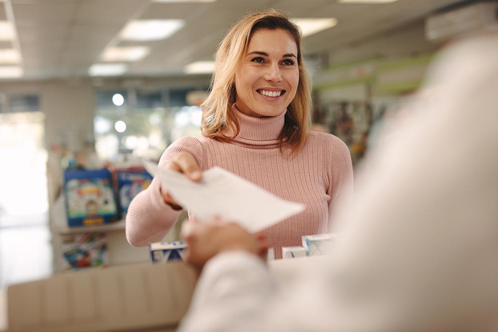woman at a pharmacy turning in a prescription