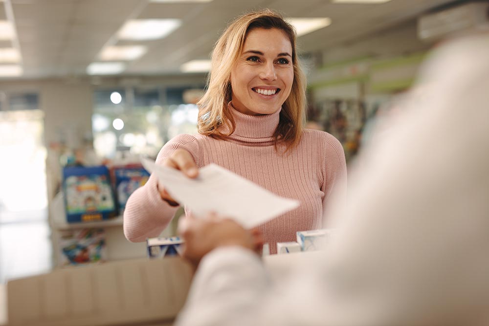 woman at a pharmacy turning in a prescription
