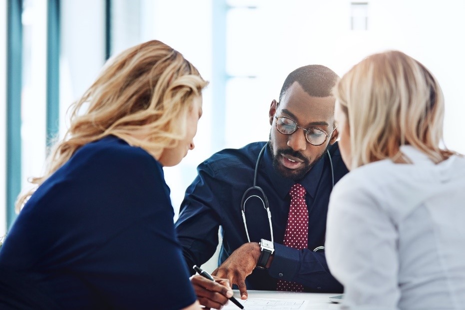  Two women speaking with their healthcare provider to submit a precertification request.