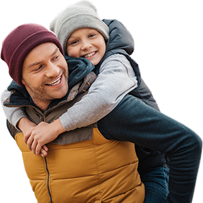 happy father piggybacking adorable smiling son in forest