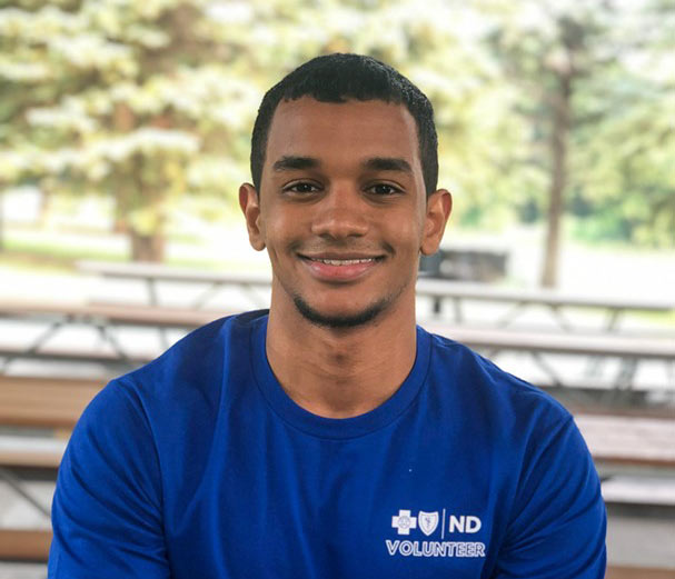 Abubakar Abdikadir, 2021 BCBSND IT Solutions Delivery intern poses for a picture while sitting on a picnic bench.