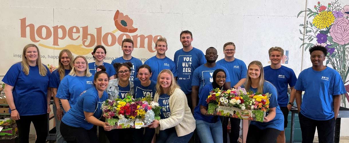 Katie Ernst (left) and interns pose for a group photo while volunteering at Hope Blooms.