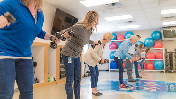 Employees lifting dumbbells in an exercise room