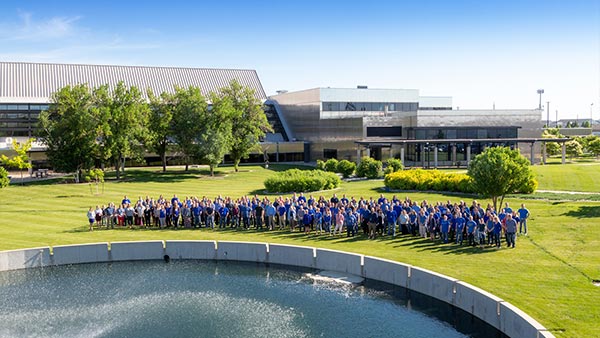 Employee large group photo outside BCBSND headquarters with fountain in foreground