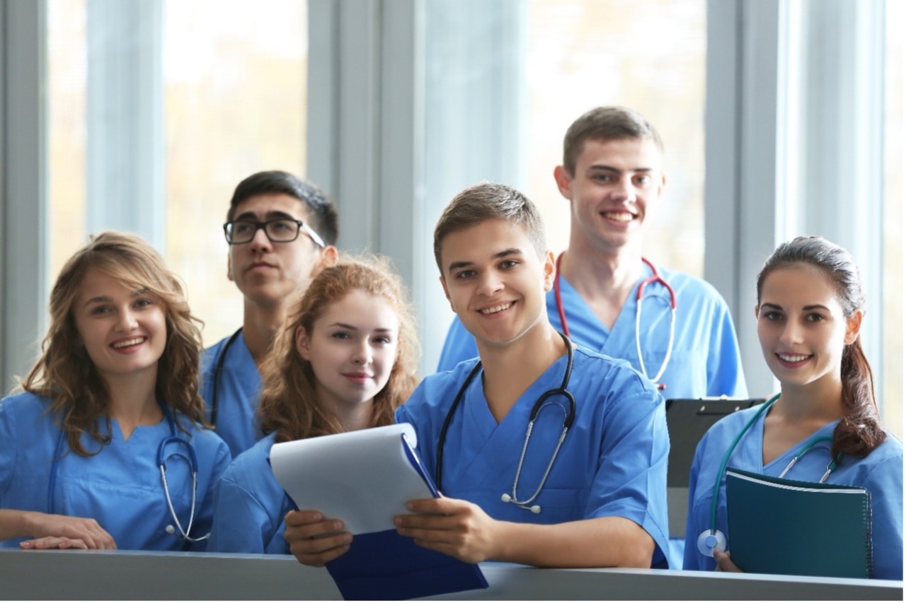 Group of healthcare students smiling and wearing scrubs