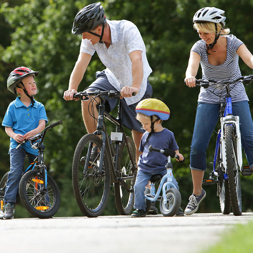 Family of four riding bike in their community