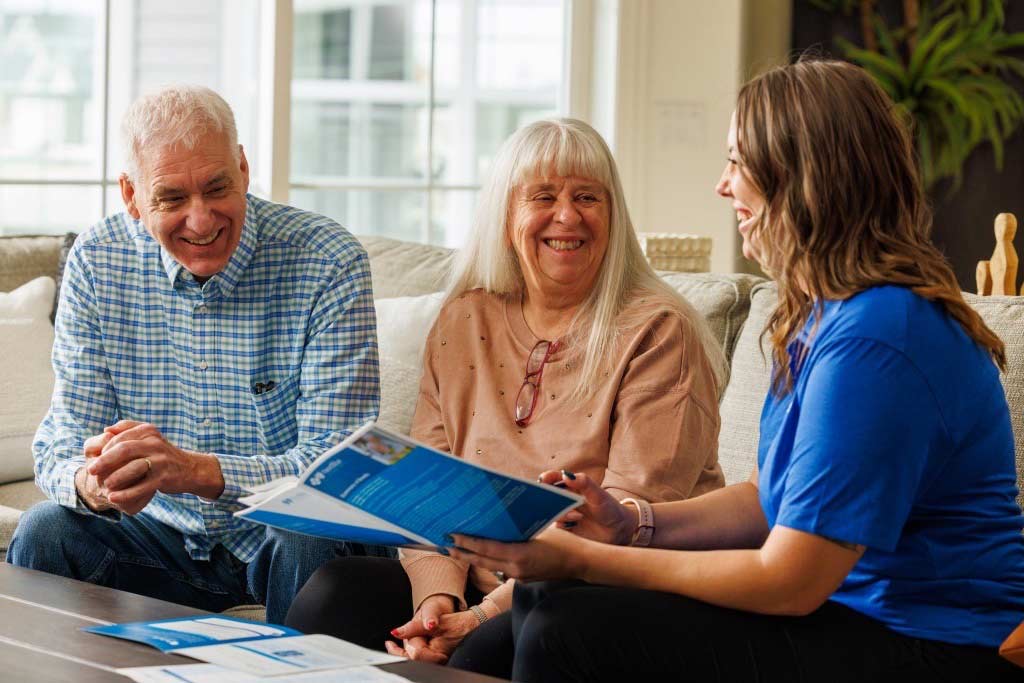 A sales representative works with a couple regarding their Medicare open enrollment options