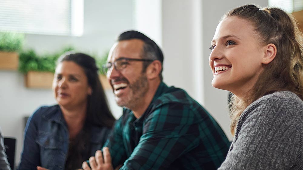 Beautiful smiling caucasian business woman siting in boardroom meeting with coworkers