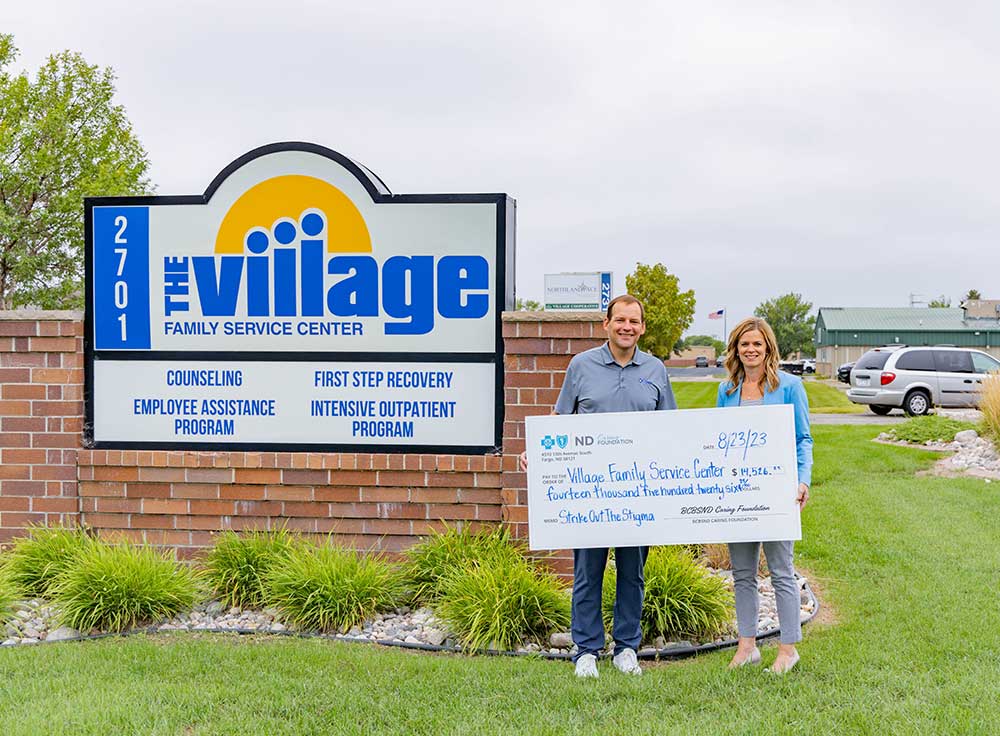 President and CEO Dan Conrad presenting a check to the Village Family Service Center