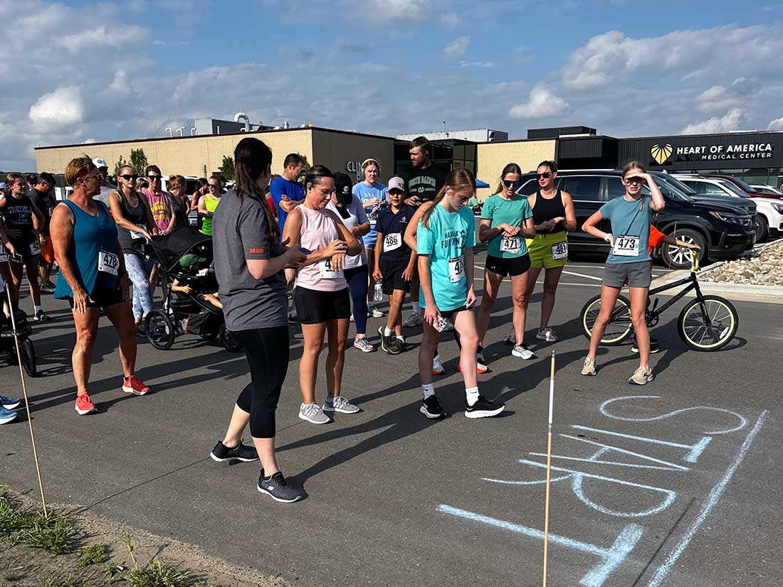 Community members lined up at the start line in front of Heart of America’s office to run the annual community 5K