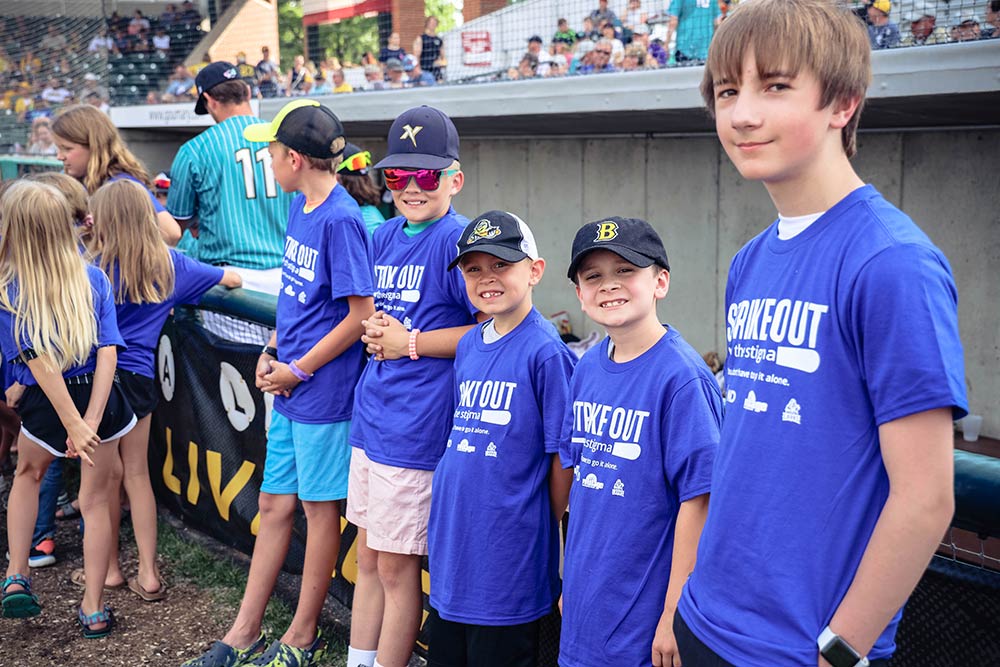 Kids wearing Strike out the Stigma T-shirts at a baseball game