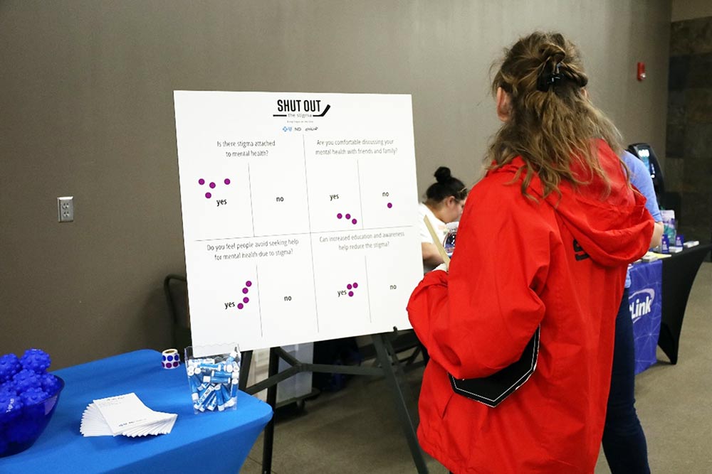 Hockey fan looking at Shut Out the Stigma mental health poster