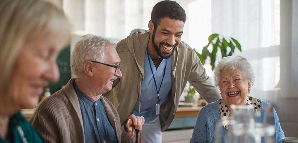 Young health care worker at senior center laughing together