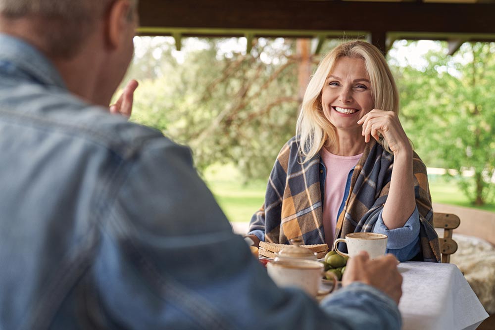 Happy mature couple having breakfast in holiday home