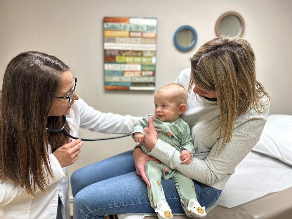 Doctor with stethoscope giving a baby a checkup