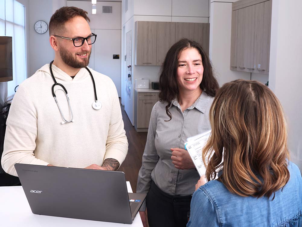 A woman meeting with healthcare personnel at a VitellaCare clinic