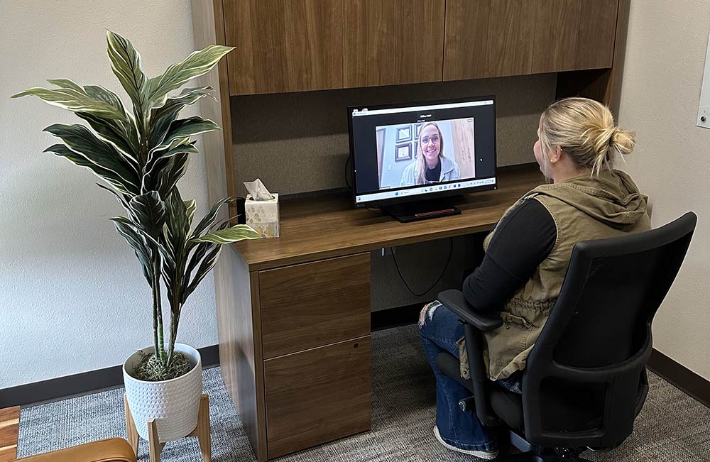 Woman using a computer for a telehealth visit with a doctor